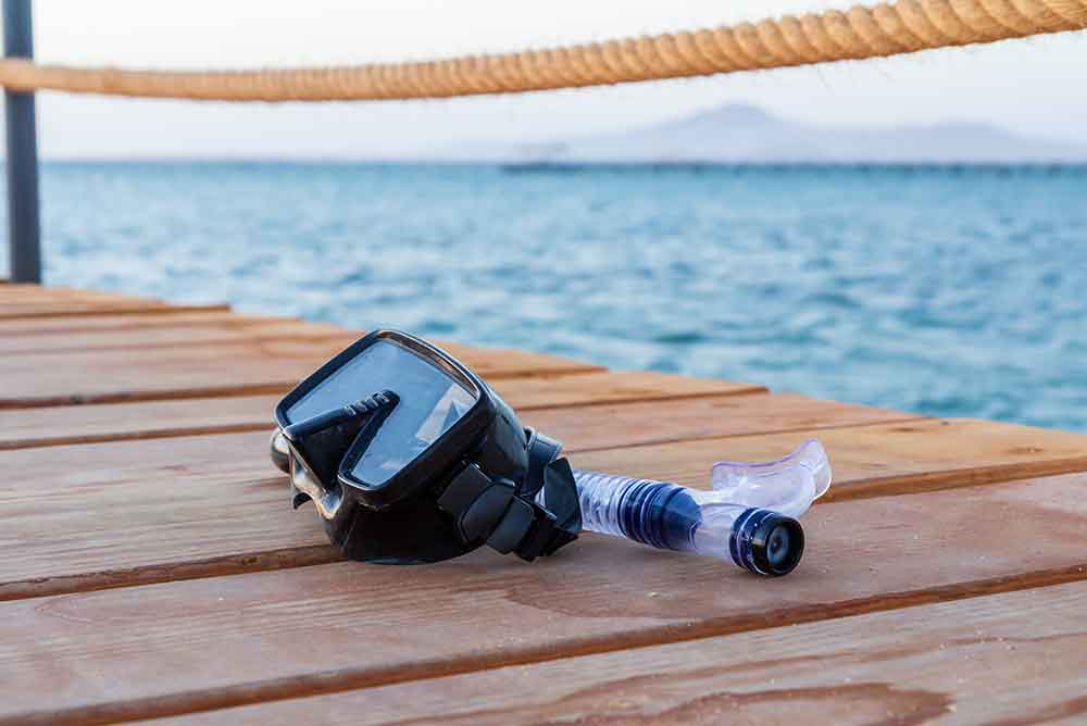 47295726_dive-mask-and-snorkel-for-professionals-on-wooden-pier