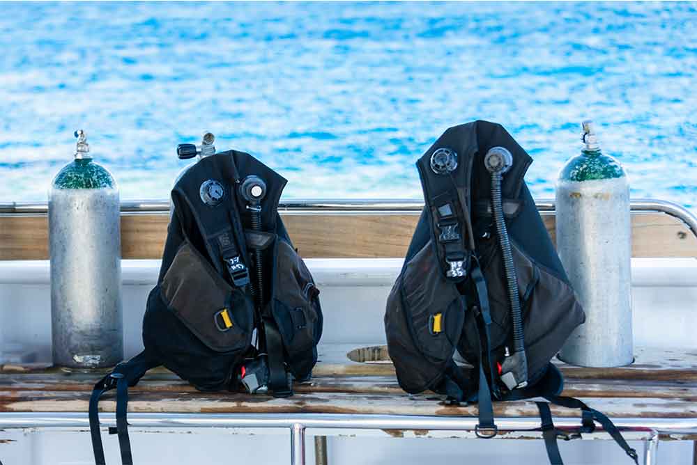 63523280_concept-of-scuba-diving-with-tank-and-equipment-lying-on-a-boat-over-blue-sea-and-sunshine